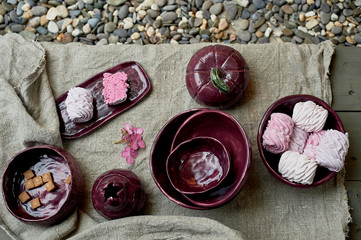 Set of handmade ceramics in purple on a piece of gray burlap. Rustic style. Clay modeling