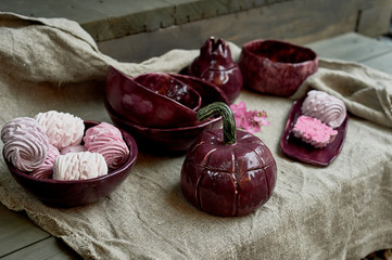 Set of handmade ceramics in purple on a piece of gray burlap. Rustic style. Clay modeling