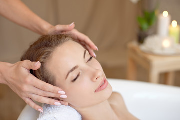 Fototapeta na wymiar Woman face with perfect skin doing facial massage in a bathtub.
