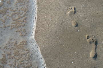 Traces on the sand washed off with a sea wave. the sea destroys traces of human presence. 