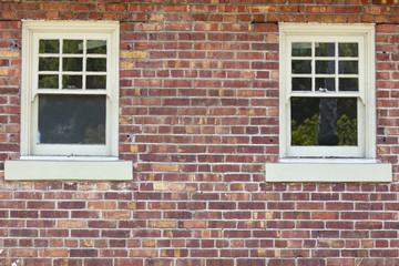 Fototapeta na wymiar Vintage variegated brick wall and two windows