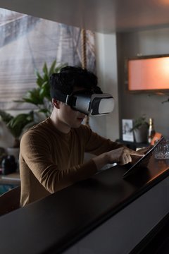 Man in virtual reality headset using digital tablet 