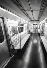 Black and white picture of a New York City subway car interior, USA.