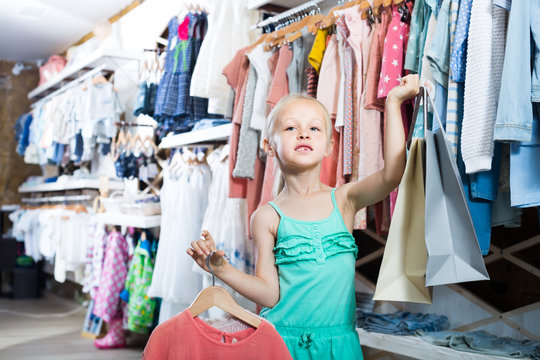 little girl in children clothes shop