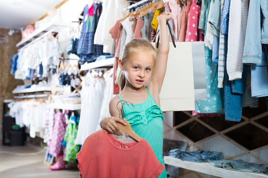 little blonde girl in children clothes shop