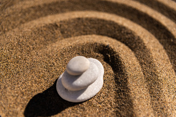 Fototapeta na wymiar zen meditation stone in sand, concept for purity harmony and spirituality, spa wellness and yoga background