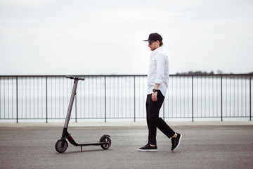 Photo of modern man with electric scooter at the street