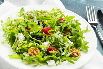 Salad with berry, nuts, goat cheese, olive oil.