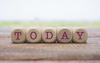 Today word written on cube shape wooden blocks on wooden table.