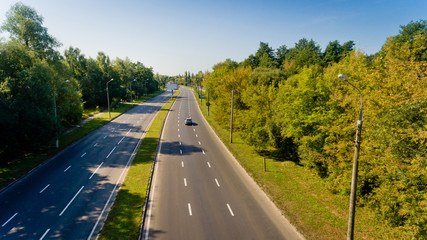 Aerial view of asphalt road passes through forest.