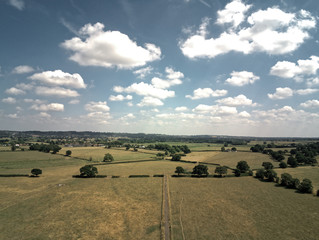 Aerial view on cheshire plains and fields. Summer sky with white clouds