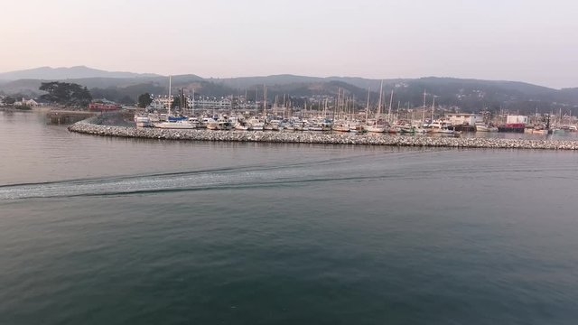 Aerial drone shot of a boat crossing past a marina.
