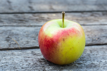 Ripe red and yellow apple on wooden table. Apple in garden. Vegetarian concept. Autumn harvest. Still life food.