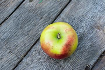 Ripe red and yellow apple on wooden table. Apple in garden. Vegetarian concept. Autumn harvest. Still life food.