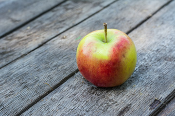 Ripe red and yellow apple on wooden table. Apple in garden. Vegetarian concept. Autumn harvest. Still life food.