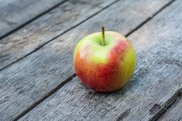 Ripe red and yellow apple on wooden table. Apple in garden. Vegetarian concept. Autumn harvest. Still life food.
