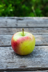 Ripe red and yellow apple on wooden table. Apple in garden. Vegetarian concept. Autumn harvest. Still life food.