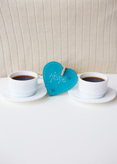 two cups of coffee on the table that says home.