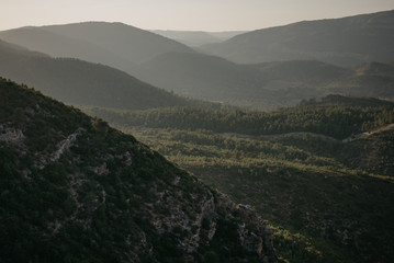 A lot of huge beautiful hills covered with forest and with the hill on the front in the evening in Spain