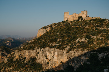 An ancient castle on the top of the hill above the valley in Spain on the sunset lights. El Castillo de Chirel. 