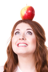 Woman holds on head apple fruit looking up