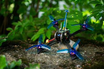 Blue race drone for fpv first person view for racing with quadcopters with carbon frame in nature green background.