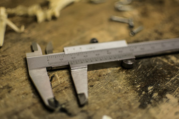 Metal caliper in a wood workshop and wood shavings with sliding calipers.