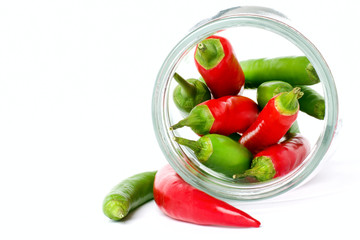 Colorful peppers in glass jar on white background. Vegan food concept