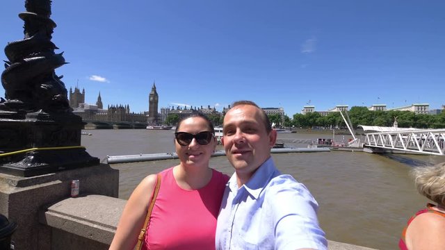 Professional video of couple taking selfie with a view of Big Ben and Thames river in London in 4k slow motion 120fps