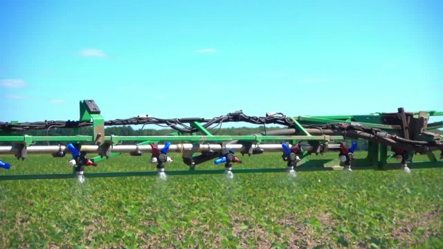 A view of the spray nozzle while working in the field. Sprayer nozzle in operation, tractor sprayer works in the field.