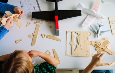 teacher and kids making toy wooden planes