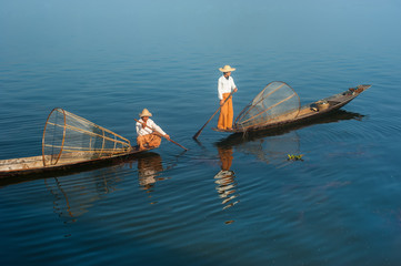 Burmese fisherman on bamboo boat catching fish. Myanmar