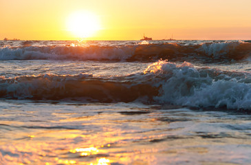 Obraz premium Sunset over the sea. Reflection of sunlight in the sea waves. Red sky in the rays of the sunset.