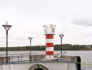Naklejka premium Red sea white lighthouse. Seagulls sitting on a lighthouse.