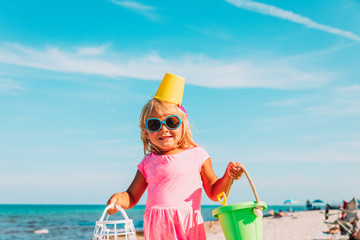 cute little girl with toys on public beach