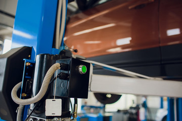 Mechanic in uniform lying down and working under car at auto service garage,copy space.