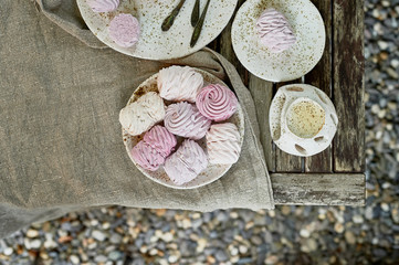 Summer tea in the fresh air. On plates prepared marshmallows and teaspoons are. Served in a rustic...