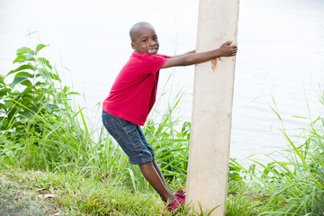 Naklejka na ściany i meble portrait of a little boy climbing a pole