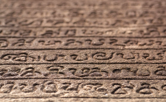 Ancient letter with words on Sinhalese language, on wall of 12th century stone temple of Polonnaruwa, Sri Lanka - Powered by Adobe