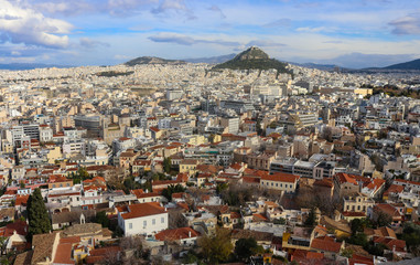 Fototapeta na wymiar View of the rooftops of Athens with their interesting patios and roof gardens looking north over Thiseio toward Mount Lycabettus perched high on a hill and crowned with the Chapel of St George and a t