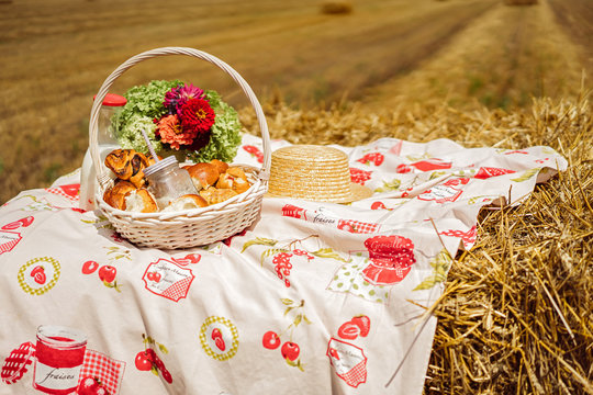 A basket of milk and pastries on a haystack.