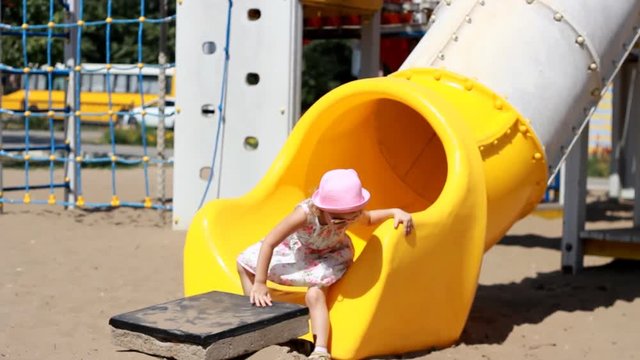 Child girl is playing on the playground. Attractions and entertainment for children