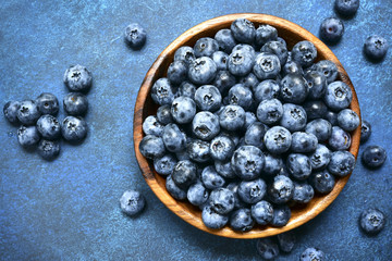Fresh ripe blueberry in a wooden bowl.