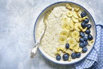 Oat porridge with banana, nuts  and fresh blueberry.Top view with copy space.