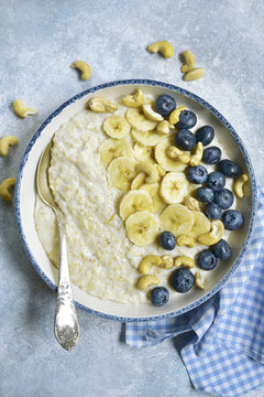 Oat porridge with banana, nuts  and fresh blueberry.Top view.