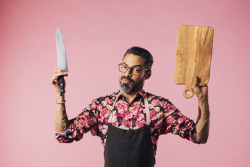 Smiling chef holding knife and cutting board