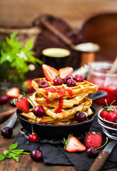 Belgian waffles with fresh berries and jam for breakfast