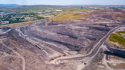 Aerial drone view of a huge opencast coal mine cut into a rural hilly area (Dowlais, Merthyr Tydfil, Wales)