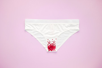 Woman white panties with glitter on pastel colorful background. Menstruation, woman's health, virginity, first sex. Conceptual minimal still life
