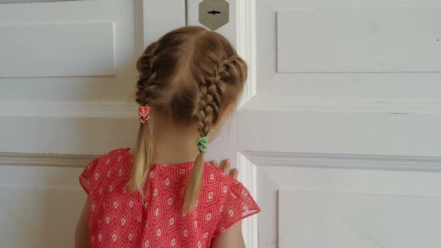 Little girl peeking through the door